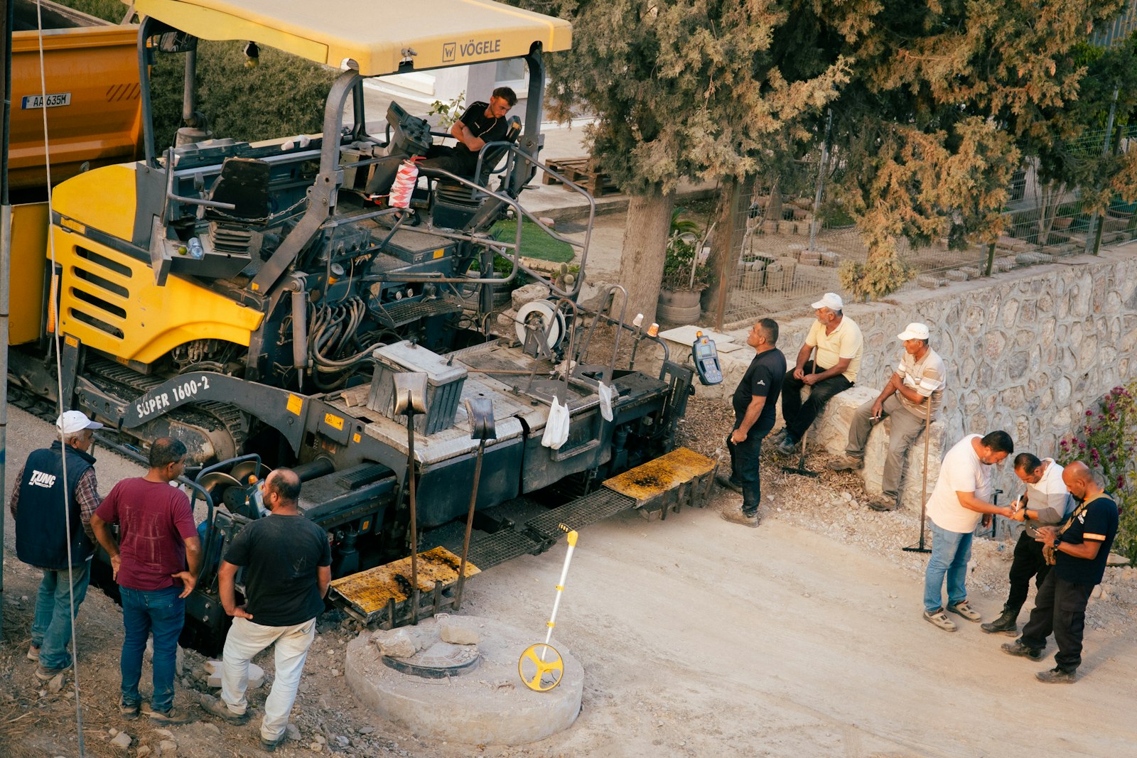 Hurley Asphalt paver laying fresh asphalt at sunrise